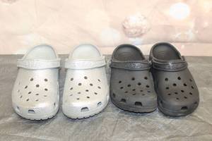 lot 203 image: TOTAL OF 2 PAIR CROCS - SILVER 7M 9W  BLACK 7M 9W&nbsp