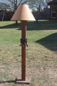 lot 77 image: WOOD FLOOR STANDING  LAMPWITH VINTAGE STYLE COWBOY SPURS  &  LAMP SHADE  5FT .H