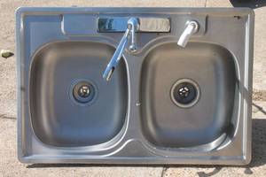 lot 4 image: Drop-in double basin stainless steel kitchen sink, featuring a chrome-plated faucet with a single-lever handle and a white side sprayer attachment.