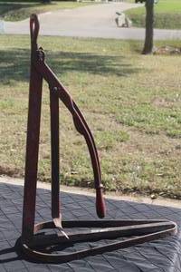 lot 13 image: Vintage red cast-iron manual tire bead breaker tool with a hinged lever mechanism, showing minor surface wear and paint loss.