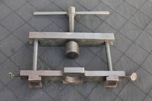 lot 31 image: Heavy-duty steel adjustable flaring tool or specialized vise, featuring a center screw handle and side thumb screws.