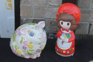 lot 43 image: Pair of vintage ceramic piggy banks, including a round floral-painted pig and a figure of a girl in a red bonnet.