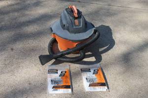 lot 45 image: &nbspRidgid wetdry shop vacuum with attached hose, nozzle, and two packages of replacement filter bags.
