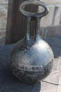 lot 46 image: Vintage heavy black cast iron round weight with attached attachment loop, showing minor surface wear and patina.