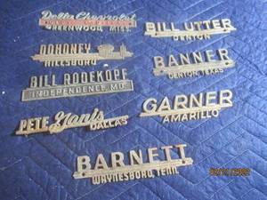 lot 77 image: VINTAGE METAL DEALERSHIP EMBLEM BADGES  LOT OF 8.