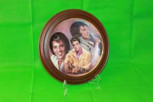 lot 2 image: ELVIS PRESLEY ,ELVIS PRESLEY  ,EIGHTH IN THE ELVIS REMEMBERED SERIES COLLECTION PLATE  ,No 1177A , ARTIST SUSIE MORTON ,WITH  VAN HYGAN & SMYTHE WOOD FRAME 13.5 DIAM