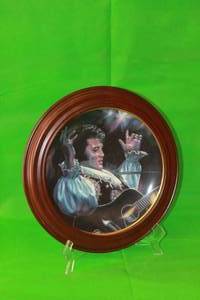 lot 5 image: ELVIS PRESLEY ,MOODY BLUES ,SEVENTH IN THE REMEMBERED SERIES COLLECTION PLATE ,No 0107A,ARTIST SUSIE MORTON,WITH WOOD VAN HYGAN & SMYTHE FRAME, 13.5 DIAM