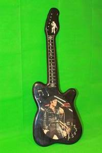 lot 59 image: VINTAGE ELVIS PRESLEY , KING LIVES ,GUITAR SHAPED WOODLACQUERED WALL CLOCK , 32 H