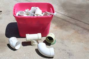 lot 176 image: TOTE OF PVC ELBOWS HUBS AND MORE SEE PICS